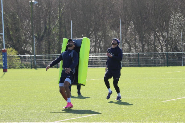 Two people on a rugby oitch with one using a Aerial Contest Bag